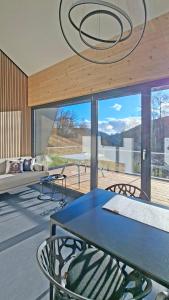 a dining room with a table and chairs and a large window at SMART LODGES Bad Rippoldsau in Bad Rippoldsau