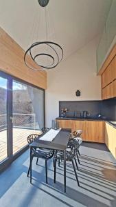 a dining room with a table and chairs and a kitchen at SMART LODGES Bad Rippoldsau in Bad Rippoldsau