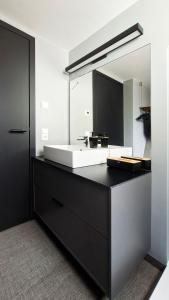 a bathroom with a sink and a large mirror at SMART LODGES Bad Rippoldsau in Bad Rippoldsau +26 photos