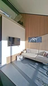 a living room with a couch and a flat screen tv at SMART LODGES Bad Rippoldsau in Bad Rippoldsau