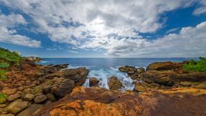 a view of the ocean from a rocky beach at Rumassala Villas in Unawatuna
