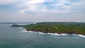 an island in the ocean with a lighthouse on it at Rumassala Villas in Unawatuna