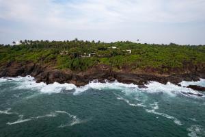 an aerial view of a house on a rocky island at Rumassala Villas in Unawatuna