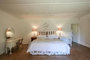 a bedroom with a bed and a desk and a mirror at Lavender Trout Guest Farm in Nottingham Road +74 photos