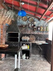 a kitchen with a stove and a table in it at Chalé Santarém, located in Mosqueiro! in Belém