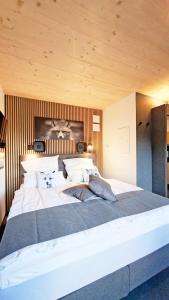 a large white bed in a bedroom with a wooden ceiling at SMART LODGES Bad Rippoldsau in Bad Rippoldsau