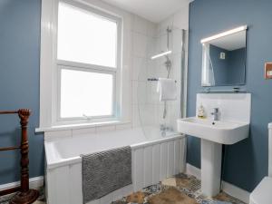 a bathroom with a tub and a sink and a window at Meregate Cottage in Margate +22 photos