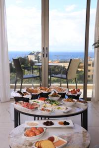 a buffet of food on a table in front of a window at Heaven Prestige Hotel in Jounieh