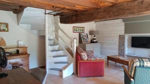 a living room with a spiral staircase and a desk at Murmures de Loire in Montjean-sur-Loire