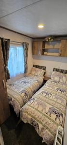 a bedroom with two beds and a window at CJ's Happy Place in Heysham