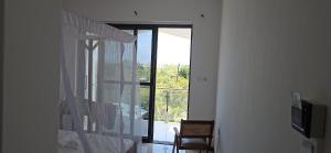 a bedroom with a window with a view of a balcony at Upole HOTEL in Nungwi