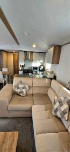 a living room with a large couch and a kitchen at CJ's Happy Place in Heysham