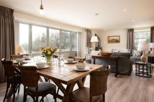 a living room with a wooden table and chairs at Old Granary House in Chesters +33 photos