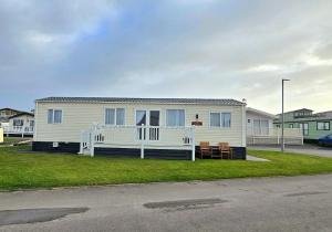 a white house with a porch and a yard at CJ's Happy Place in Heysham