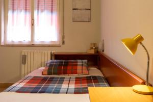 a bedroom with a bed and a desk with a lamp at Albergo Ristorante Brera in Inveruno +17 photos