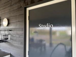 a sliding glass door to a shop with a sign on it at Studio op Camperplaats Vechtdal in Nieuwleusen