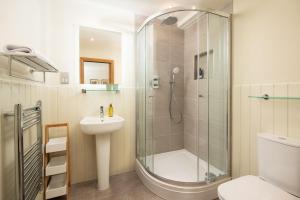 a bathroom with a shower and a toilet and a sink at Old Granary House in Chesters