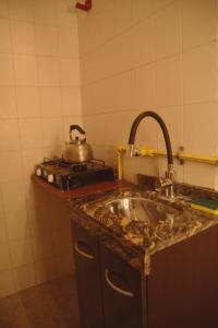 a kitchen with a sink and a pot on a stove at Departamento espiral in Embalse