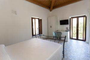 a white room with a bed and a kitchen at Villa De Santis in Praia a Mare