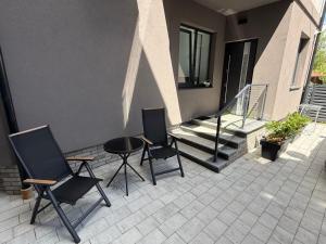 a patio with two chairs and a table and stairs at Urban Nest in Truskavets