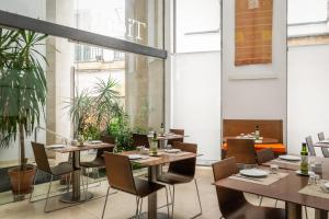 a restaurant with tables and chairs and plants at BYPILLOW Tiento in Cádiz