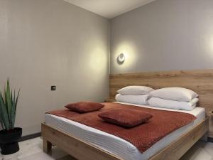 a bedroom with a bed with two pillows on it at Urban Nest in Truskavets