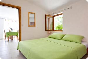 a bedroom with a green bed and a table at Family home away on the beach, free parking at the house in Marusici 