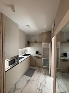 a kitchen with white marble counters and a microwave at Urban Nest in Truskavets