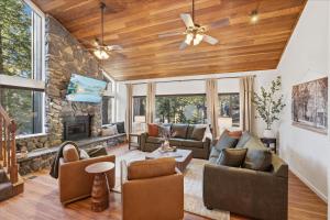 a living room with wood ceilings and a stone fireplace at Yosemite Spirit in Yosemite West +45 photos