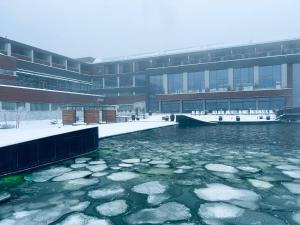 a building with ice in the water in front of it at Hotel Ramonda in Boljevac