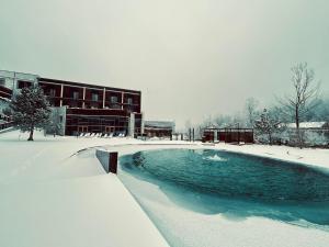 a swimming pool covered in snow in front of a building at Hotel Ramonda in Boljevac
