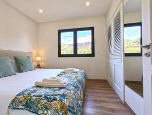 a bedroom with a bed and two windows at O Nosso Refúgio in Água de Pau