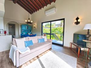 a living room with a couch and a tv at O Nosso Refúgio in Água de Pau