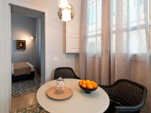 a room with a table with a bowl of oranges on it at Varò Apartment in Taormina