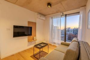 a living room with a couch and a large window at Live Suites in Montevideo