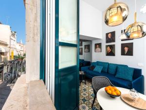 a living room with a blue couch and a table at Varò Apartment in Taormina