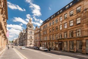 a city street with buildings and a clock tower at Glasgow City Flats - Merchant City in Glasgow