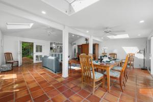 a dining room and living room with a table and chairs at Alaeloa 35 in Kapalua