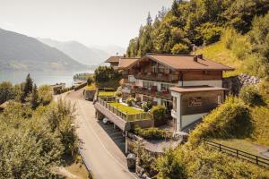 a house on the side of a hill with a road at Berg- & Seeblick Pfefferbauer in Zell am See
