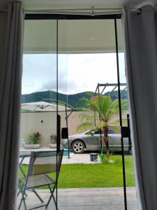a glass window with a table and a car in a driveway at Enseada Beach in São Sebastião