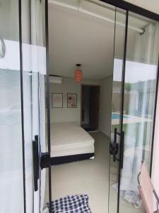 a small bedroom with a bed and a mirror at Enseada Beach in São Sebastião