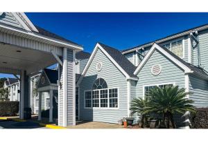 a white house with a gambrel roof at Studio 6 Mobile AL in Mobile