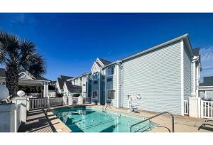 a swimming pool in front of a house at Studio 6 Mobile AL in Mobile