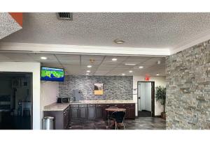 an office lobby with a counter and a tv on a wall at Studio 6 Mobile AL in Mobile