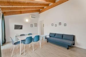 a living room with a blue couch and a table and chairs at Il Parco Apartment- Nature & Relax-Road To 5Terre in Beverino