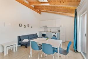 a living room with a white table and blue chairs at Il Parco Apartment- Nature & Relax-Road To 5Terre in Beverino