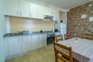a kitchen with white cabinets and a table with chairs at Edificio Prieto VIV 2C in Puerto del Rosario