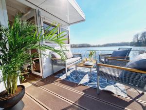 a porch on a boat with chairs and plants at Neues Hausboot für 4 Personen Müritz und Plauer See in Lübz