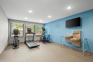 a gym with exercise equipment and a flat screen tv at WoodSpring Suites Charlotte Northlake in Charlotte