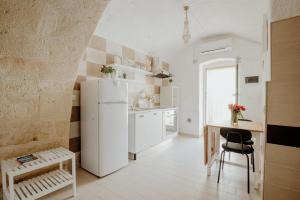 a kitchen with a white refrigerator and a table at Palazzo Pezzolla Apartments in Monopoli